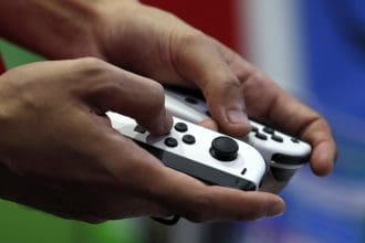Una persona sujeta con las manos unos controladores Nintendo Switch. EFE/EPA/RUNGROJ YONGRIT