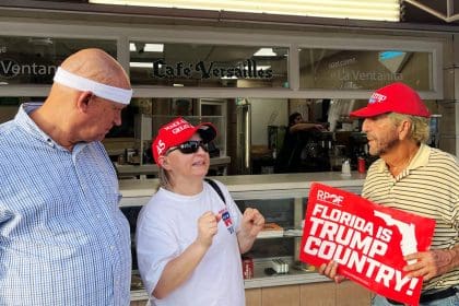 Ania Fresquet (c), una votante inscrita en la lista demócrata pero que vota por Donald Trump, habla con Osvaldo Hernández (i) y Miguel Saavedra (d), dos miembros de la 'Vigilia Mambisa', el lunes 4 de noviembre de 2024 en frente del icónico restaurante Versailles de la Pequeña Habana en Miami, Florida (EE.UU.). EFE/Ana Milena Varón