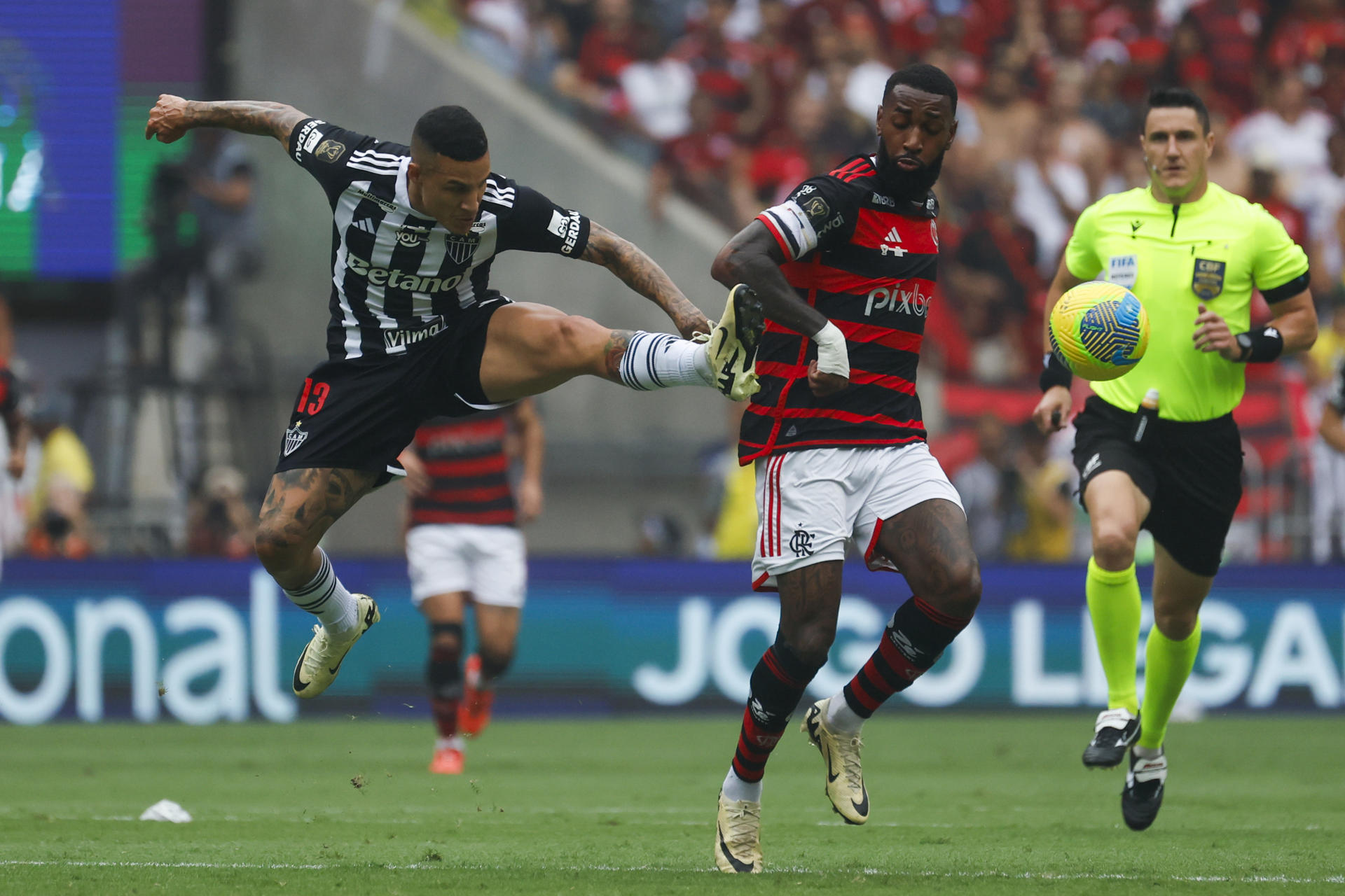 Guilherme Arana (i) disputa el balón con Gerson (d) este domingo en el estadio Maracaná durante el partido de ida que la Copa do Brasil que Flamengo ganó por 3-1 al Atlético Mineiro. EFE/ Antonio Lacerda