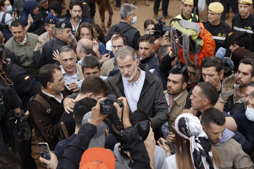 El rey Felipe VI habla con vecinos de Paiporta, epicentro de las inundaciones, durante su visita este domingo a esta localidad valenciana, donde él y su comitiva, con la reina, el presidente del Gobierno, Pedro Sánchez, y el presidente regional de Valencia, Carlos Manzón, fueron recibidos con gritos de "fuera". EFE/Biel Aliño