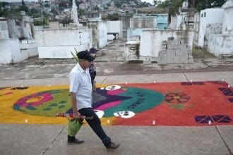 Un hombre camina al Cementerio General donde pondrá flores a un familiar fallecido, en el marco de Día de Muertos, este sábado de la ciudad de Comayagüela (Honduras). EFE/Gustavo Amador