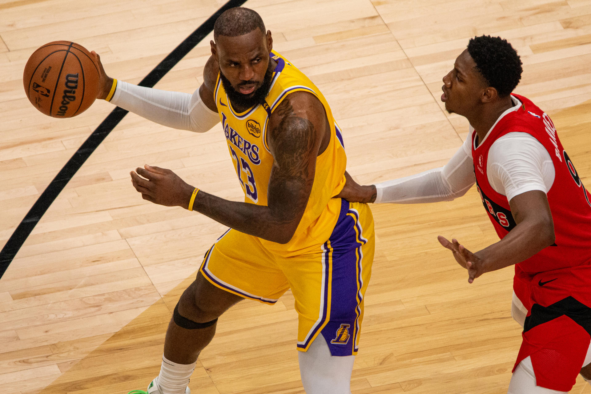 RJ Barrett (d) de los Toronto Raptors disputa el balón con LeBron James de los Ángeles Lakers, este viernes durante un partido de la NBA en el Scotiabank Arena, en Toronto (Canadá). EFE/ Julio César Rivas