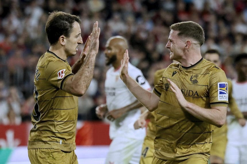 El capitán de la Real Sociedad, Mikel Oyarzabal (izda), celebra con su compañero Zubimendi el segundo gol conseguido ante el Sevilla FC, durante el partido de LaLiga que les enfrentó en el estadio Sánchez Pizjuán de Sevilla este domingo. EFE/José Manuel Vidal