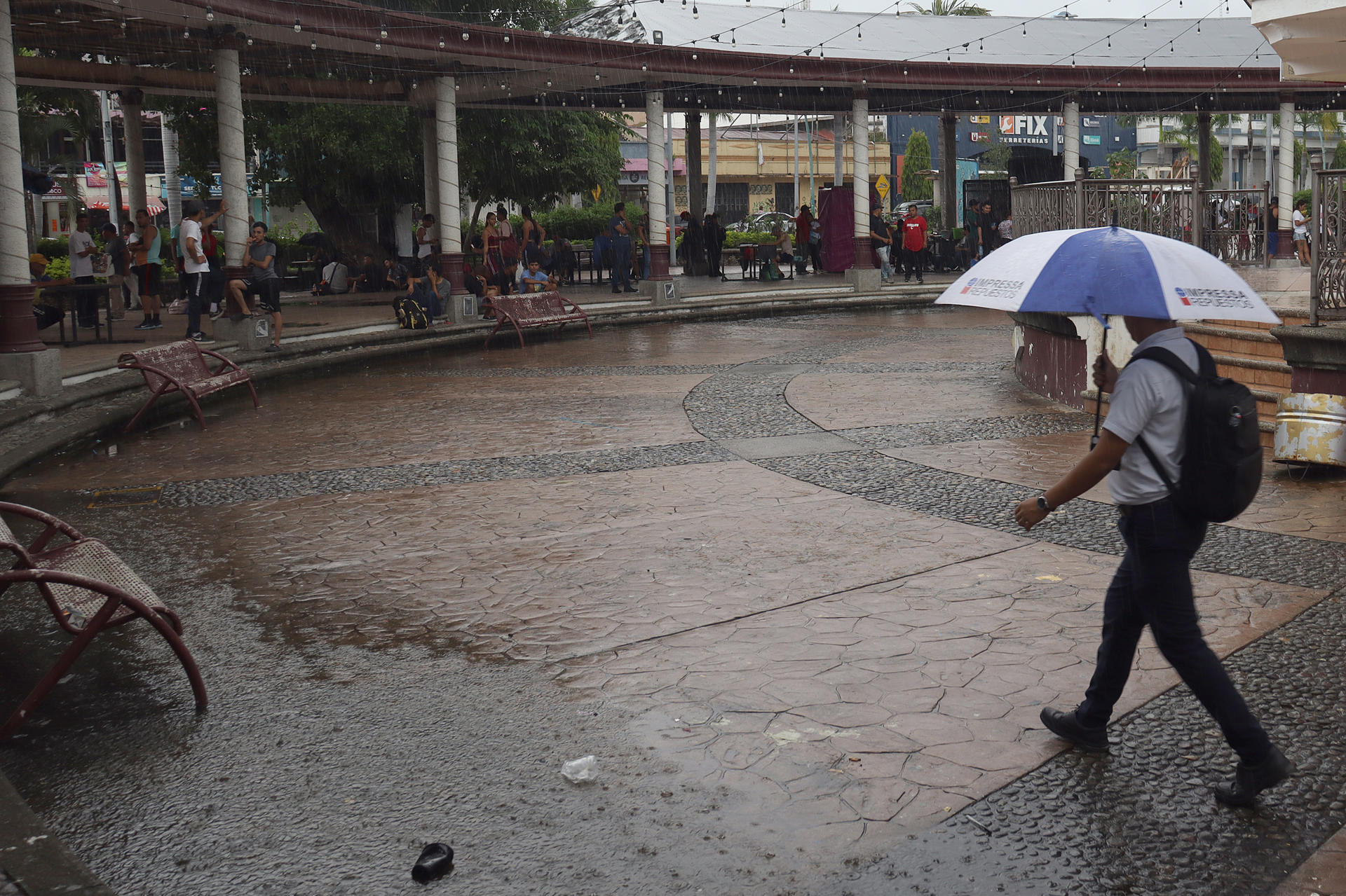 Migrantes se resguardan de la lluvia en una plaza pública este marte, en el municipio de Tapachula en el estado de Chiapas (México). EFE/ Juan Manuel Blanco