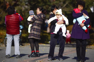 Fotografía de archivo que muestra a mujeres que sujetan en brazos a bebés en un parque de Pekín, China. EFE/Diego Azubel