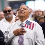 Imagen de archivo de nuevos ciudadanos estadounidenses que cantan el himno nacional durante una ceremonia de naturalización en un centro de convenciones de Los Ángeles (EE.UU.). EFE/ Etienne Laurent