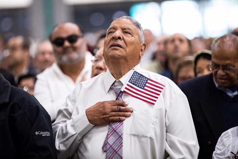 Imagen de archivo de nuevos ciudadanos estadounidenses que cantan el himno nacional durante una ceremonia de naturalización en un centro de convenciones de Los Ángeles (EE.UU.). EFE/ Etienne Laurent