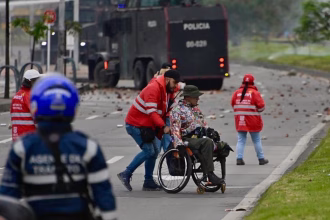 Fotografía tomada de la cuenta en X @SeguridadBOG de la Secretaría de Seguridad de Bogotá de un gestor de convivencia acompañando a una persona en silla de ruedas este viernes, durante una protesta en Bogotá (Colombia). EFE/ Secretaría de Seguridad de Bogotá