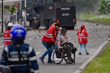 Fotografía tomada de la cuenta en X @SeguridadBOG de la Secretaría de Seguridad de Bogotá de un gestor de convivencia acompañando a una persona en silla de ruedas este viernes, durante una protesta en Bogotá (Colombia). EFE/ Secretaría de Seguridad de Bogotá